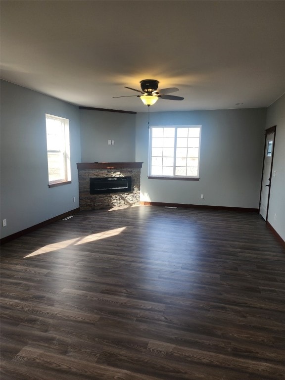 203 William Way, Newhall, IA 52315 - unfurnished living room featuring plenty of natural light, ceiling fan, a fireplace, and dark wood-style flooring