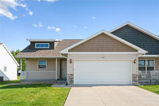 914 Deer Run Dr NE, Cedar Rapids, IA 52402 - craftsman-style house featuring a porch, stone siding, a garage, concrete driveway, and a front lawn