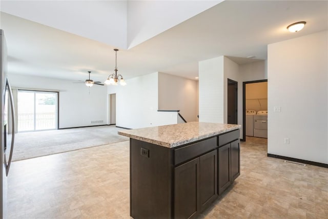 914 Deer Run Dr NE, Cedar Rapids, IA 52402 - kitchen featuring separate washer and dryer, a ceiling fan, decorative light fixtures, a center island, and stainless steel refrigerator