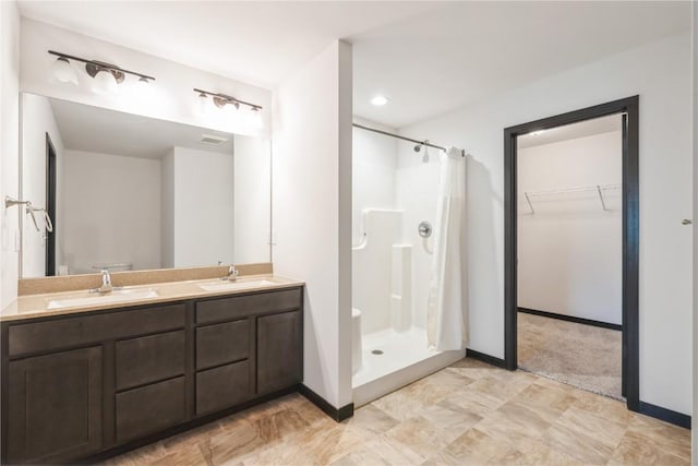 914 Deer Run Dr NE, Cedar Rapids, IA 52402 - bathroom featuring a shower stall, double vanity, and a walk in closet