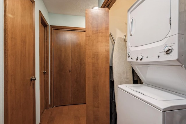 1579 Matterhorn Dr NE, Cedar Rapids, IA 52402 - washroom featuring stacked washer / drying machine and wood finished floors