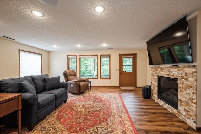 1579 Matterhorn Dr NE, Cedar Rapids, IA 52402 - living area featuring a textured ceiling, a stone fireplace, wood finished floors, and recessed lighting