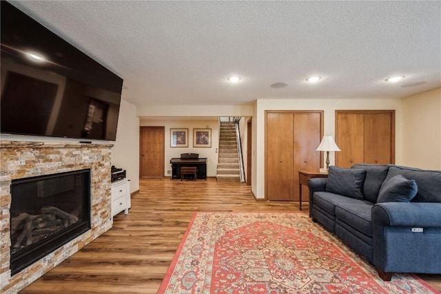 1579 Matterhorn Dr NE, Cedar Rapids, IA 52402 - living area featuring stairway, wood finished floors, a textured ceiling, recessed lighting, and a fireplace