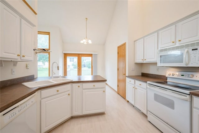 2500 Creekside Dr, Hiawatha, IA 52233 - kitchen featuring white appliances, a chandelier, a peninsula, white cabinets, and high vaulted ceiling