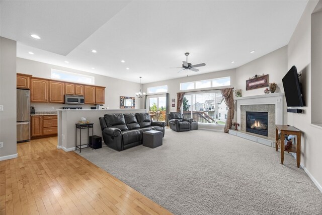 2515 Woodhill Dr SW, Cedar Rapids, IA 52404 - living area featuring a ceiling fan, recessed lighting, a tile fireplace, light wood-style flooring, and a chandelier