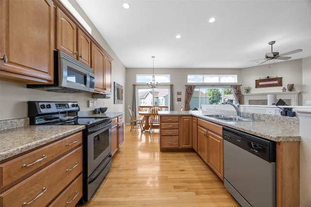 2515 Woodhill Dr SW, Cedar Rapids, IA 52404 - kitchen with appliances with stainless steel finishes, light wood-type flooring, recessed lighting, a ceiling fan, and brown cabinetry