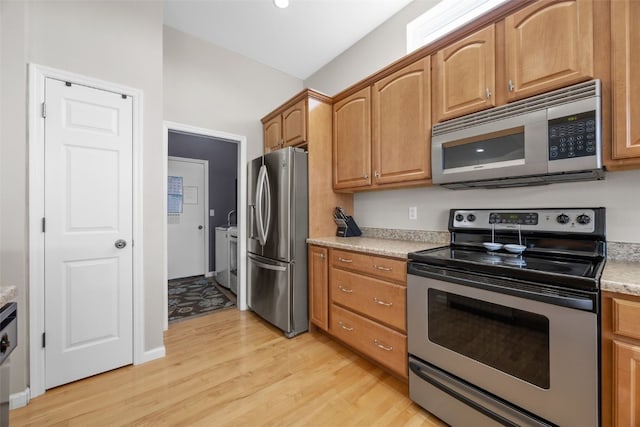 2515 Woodhill Dr SW, Cedar Rapids, IA 52404 - kitchen with appliances with stainless steel finishes, light wood finished floors, light countertops, and brown cabinets