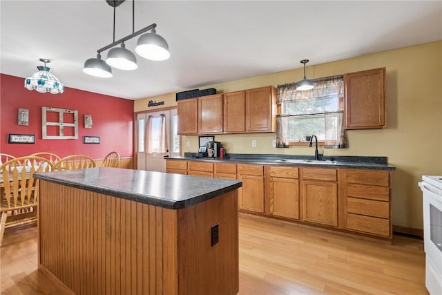 1009 W 1st St, Vinton, IA 52349 - kitchen with dark countertops, brown cabinetry, and light wood-style floors