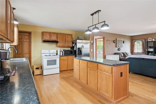 1009 W 1st St, Vinton, IA 52349 - kitchen featuring stainless steel appliances, under cabinet range hood, light wood-type flooring, a center island, and open floor plan