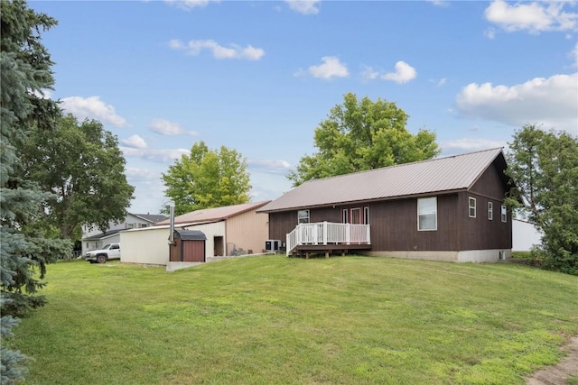 1009 W 1st St, Vinton, IA 52349 - rear view of property featuring a storage shed, a deck, and a yard