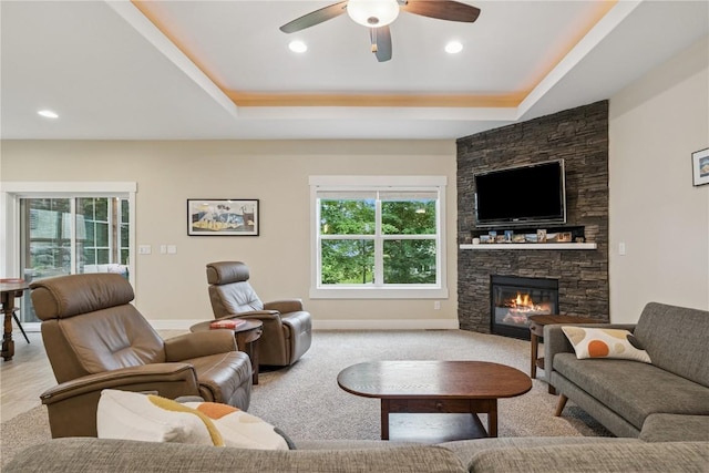 2021 Andrew Charles Dr NW, Cedar Rapids, IA 52405 - living room with ceiling fan, a raised ceiling, a stone fireplace, and recessed lighting