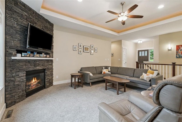 2021 Andrew Charles Dr NW, Cedar Rapids, IA 52405 - living room with a tray ceiling, a ceiling fan, carpet flooring, a stone fireplace, and recessed lighting