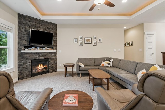 2021 Andrew Charles Dr NW, Cedar Rapids, IA 52405 - living area with a tray ceiling, carpet, ceiling fan, a stone fireplace, and recessed lighting