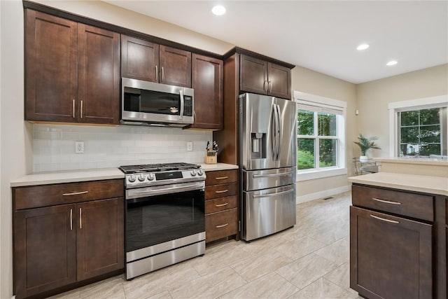 2021 Andrew Charles Dr NW, Cedar Rapids, IA 52405 - kitchen with appliances with stainless steel finishes, light countertops, decorative backsplash, dark brown cabinets, and recessed lighting