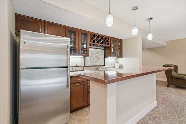 2021 Andrew Charles Dr NW, Cedar Rapids, IA 52405 - kitchen featuring freestanding refrigerator, open floor plan, glass insert cabinets, decorative light fixtures, and light colored carpet