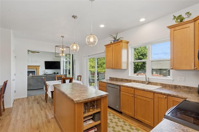 4420 Spring Meadow Pl NE, Cedar Rapids, IA 52411 - kitchen with stainless steel dishwasher, light wood finished floors, a warm lit fireplace, a center island, and hanging light fixtures