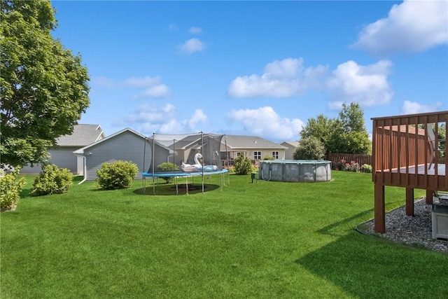 4420 Spring Meadow Pl NE, Cedar Rapids, IA 52411 - view of green lawn with a deck and a trampoline
