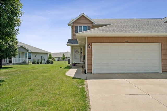 1019 Acacia Dr NE, Cedar Rapids, IA 52402 - view of front of house featuring roof with shingles, a front lawn, a garage, and concrete driveway