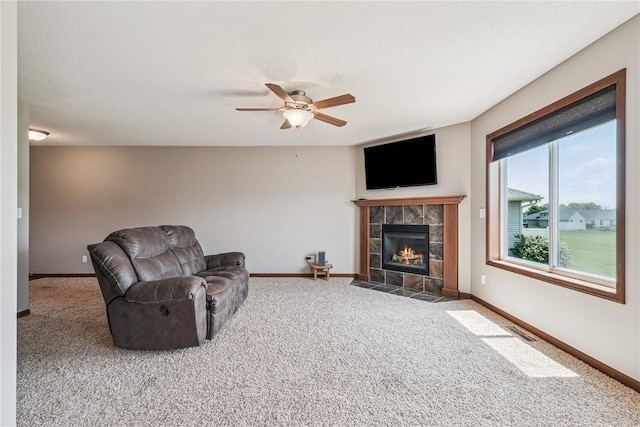 1019 Acacia Dr NE, Cedar Rapids, IA 52402 - carpeted living area with a tiled fireplace and a ceiling fan
