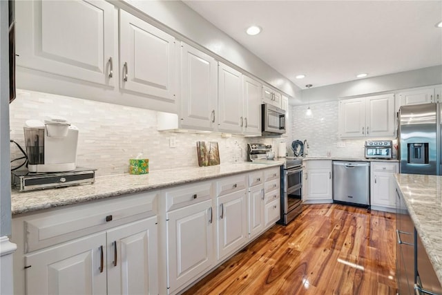 1580 Matterhorn Dr NE, Cedar Rapids, IA 52402 - kitchen featuring stainless steel appliances, white cabinets, light wood finished floors, backsplash, and recessed lighting