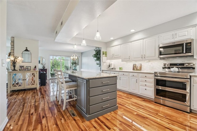 1580 Matterhorn Dr NE, Cedar Rapids, IA 52402 - kitchen featuring appliances with stainless steel finishes, gray cabinets, white cabinets, light wood-type flooring, and recessed lighting