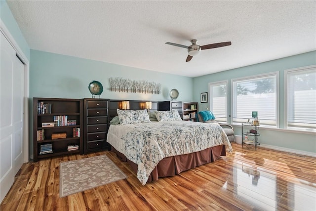 1580 Matterhorn Dr NE, Cedar Rapids, IA 52402 - bedroom featuring wood finished floors, a textured ceiling, a ceiling fan, and a closet