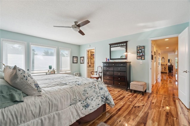 1580 Matterhorn Dr NE, Cedar Rapids, IA 52402 - bedroom featuring wood finished floors, a textured ceiling, a ceiling fan, and connected bathroom