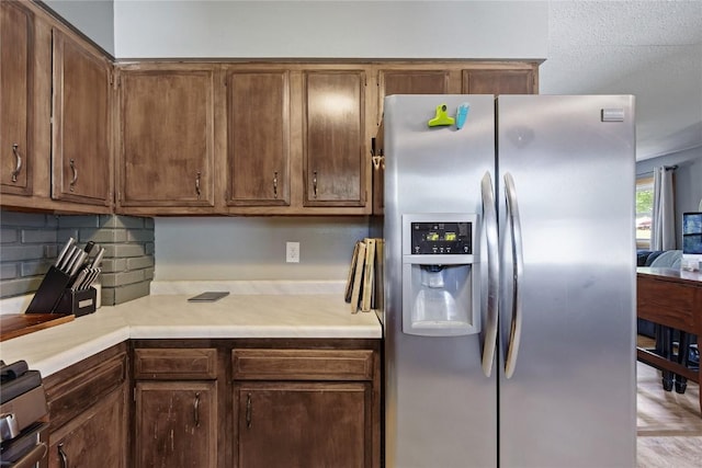 105 E Clark St, Hiawatha, IA 52233 - kitchen with stainless steel fridge, light countertops, stove, and backsplash