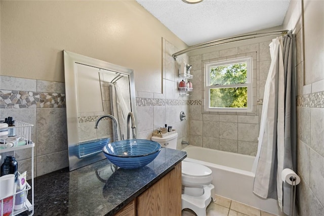 105 E Clark St, Hiawatha, IA 52233 - bathroom featuring tile walls, shower / bathtub combination with curtain, a textured ceiling, vanity, and tile patterned flooring