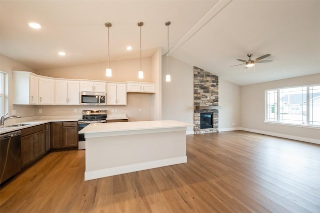 6188 Cope Dr, Marion, IA 52302 - kitchen featuring stainless steel appliances, lofted ceiling, white cabinets, wood finished floors, and light countertops