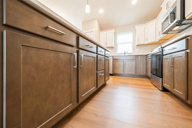 6188 Cope Dr, Marion, IA 52302 - kitchen featuring light wood-style flooring, white cabinetry, decorative light fixtures, stainless steel microwave, and recessed lighting
