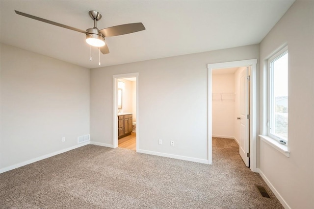 6188 Cope Dr, Marion, IA 52302 - unfurnished bedroom featuring light carpet, a spacious closet, ensuite bath, a closet, and ceiling fan