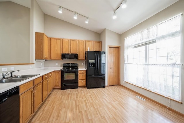 1641 Greens Way Ct, Cedar Rapids, IA 52402 - kitchen featuring black appliances, lofted ceiling, rail lighting, light countertops, and light wood finished floors