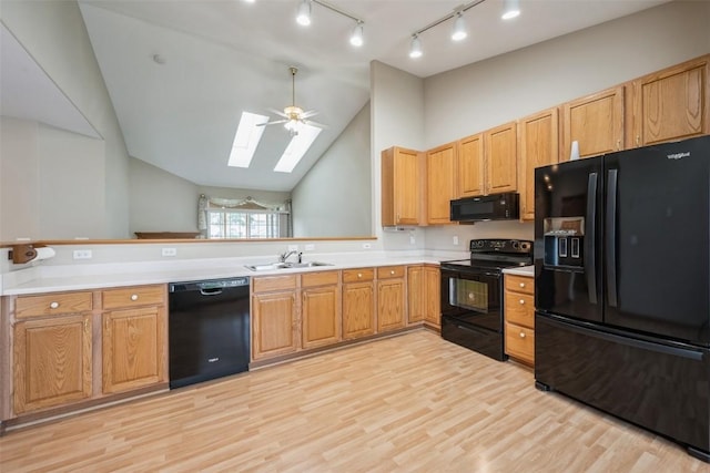 1641 Greens Way Ct, Cedar Rapids, IA 52402 - kitchen featuring black appliances, a skylight, light wood-style floors, vaulted ceiling, and light countertops