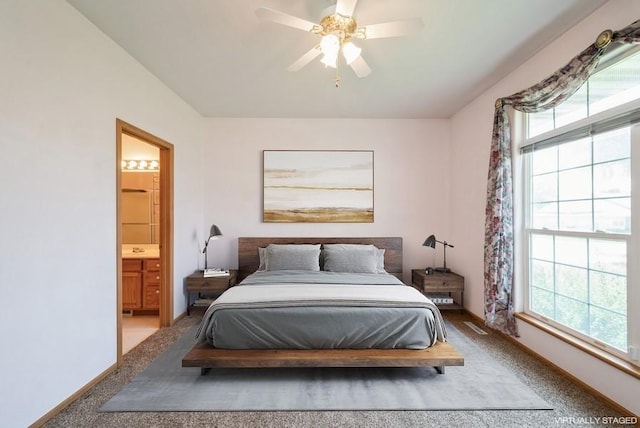 1641 Greens Way Ct, Cedar Rapids, IA 52402 - carpeted bedroom featuring multiple windows, ensuite bath, and a ceiling fan