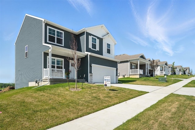 717 E Bear Dr, Tiffin, IA 52340 - view of front of house featuring a porch, driveway, a garage, and a front yard