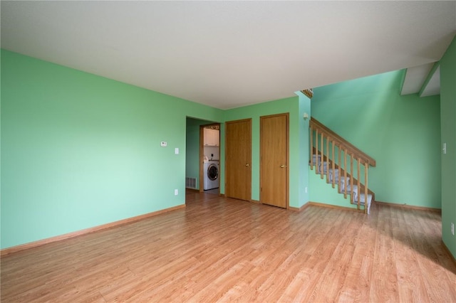6514 Fox Run Dr SW, Cedar Rapids, IA 52404 - unfurnished living room featuring washer / clothes dryer, light wood finished floors, and stairs