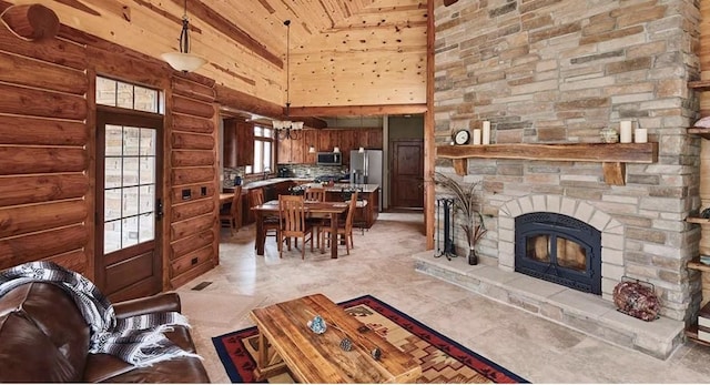 140 Falcon Dr, Montezuma, IA 50171 - living room with high vaulted ceiling, a fireplace, wooden ceiling, and log walls