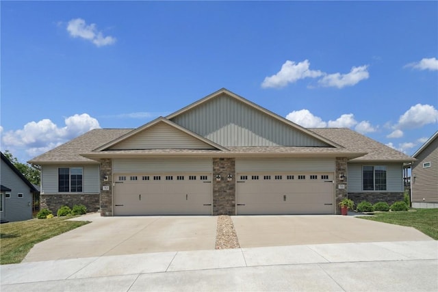 713 Hillside Dr, Tiffin, IA 52340 - craftsman-style house featuring a garage, driveway, and stone siding