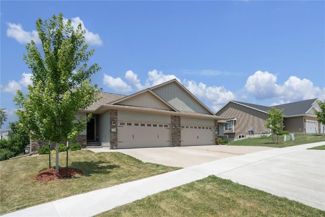 713 Hillside Dr, Tiffin, IA 52340 - ranch-style house featuring a garage, concrete driveway, a front lawn, and stone siding