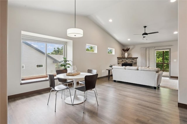 713 Hillside Dr, Tiffin, IA 52340 - dining space with lofted ceiling, ceiling fan, a stone fireplace, wood finished floors, and recessed lighting