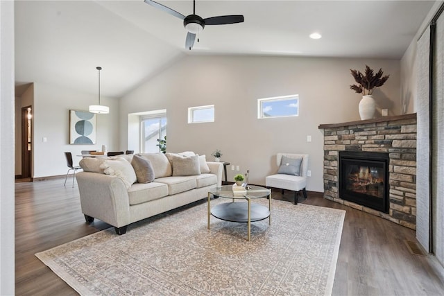713 Hillside Dr, Tiffin, IA 52340 - living room with ceiling fan, wood finished floors, a stone fireplace, and high vaulted ceiling