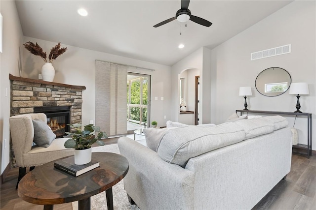 713 Hillside Dr, Tiffin, IA 52340 - living area featuring vaulted ceiling, wood finished floors, arched walkways, ceiling fan, and a stone fireplace