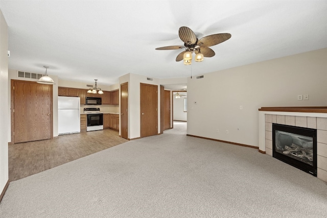 3120 Wilson Ave SW Unit 2, Cedar Rapids, IA 52404 - unfurnished living room with ceiling fan, a tile fireplace, and light colored carpet