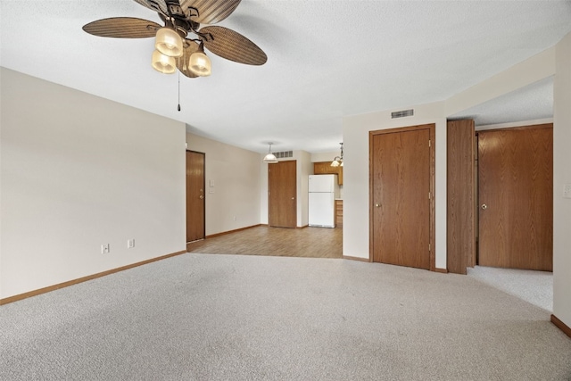 3120 Wilson Ave SW Unit 2, Cedar Rapids, IA 52404 - unfurnished living room featuring light carpet, ceiling fan, and a textured ceiling