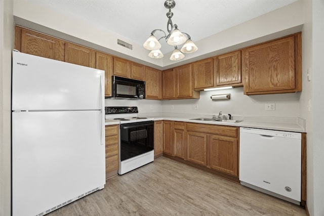 3120 Wilson Ave SW Unit 2, Cedar Rapids, IA 52404 - kitchen featuring white appliances, a chandelier, light countertops, light wood-type flooring, and brown cabinetry