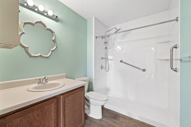 3120 Wilson Ave SW Unit 2, Cedar Rapids, IA 52404 - bathroom with a shower, vanity, wood finished floors, and a textured ceiling
