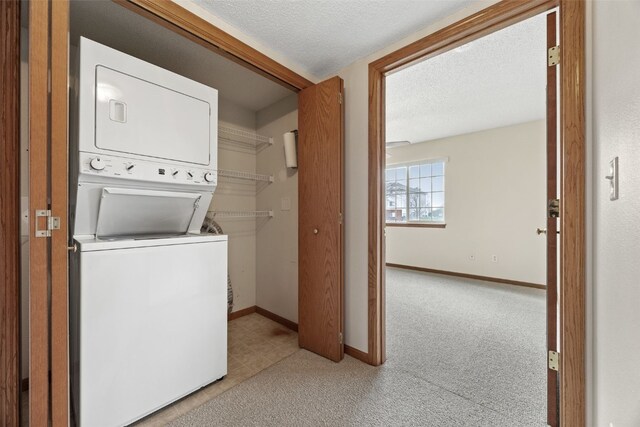 3120 Wilson Ave SW Unit 2, Cedar Rapids, IA 52404 - laundry room with stacked washer and clothes dryer, a textured ceiling, and carpet floors