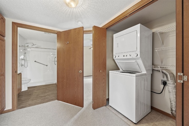 3120 Wilson Ave SW Unit 2, Cedar Rapids, IA 52404 - laundry area featuring stacked washing machine and dryer and a textured ceiling