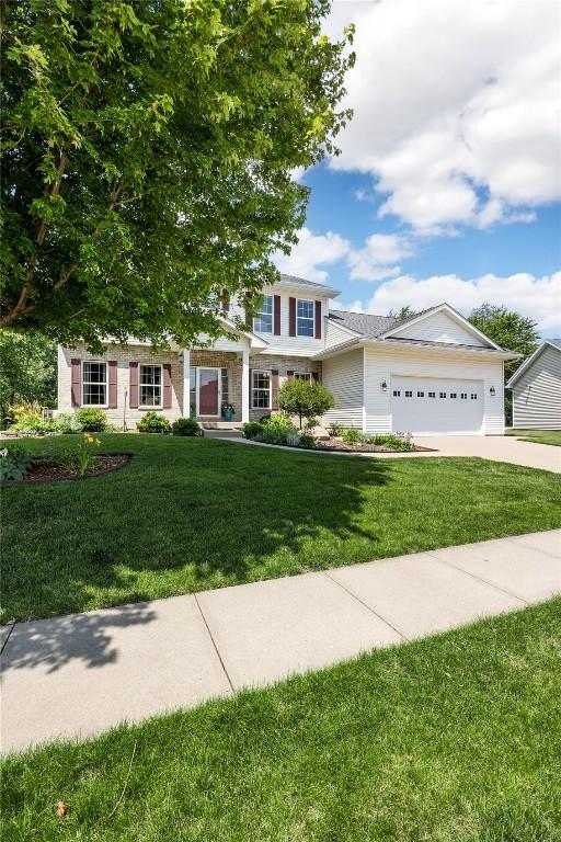 712 Willow Ct, Solon, IA 52333 - view of front of house featuring a garage, a front lawn, and concrete driveway
